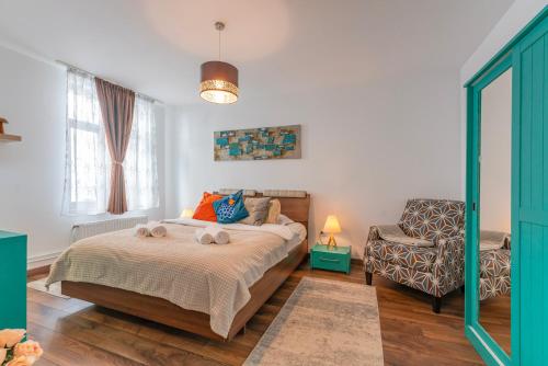 1 dormitorio con 1 cama y 1 silla en Wagner eState FEEL THE OLD TOWN VIBE en Brasov