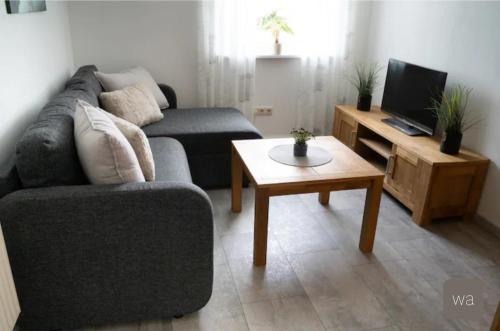 sala de estar con sofá y mesa de centro en Ferienwohnung Ahlemeier, 