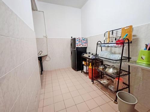 a kitchen with a refrigerator and a tiled floor at Fausal Legacy Homestay Sungai Besar in Sungai Besar