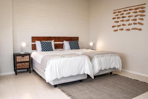 1 dormitorio con 1 cama grande con sábanas blancas y almohadas azules en The View @ Santa Maria, en Santa Maria