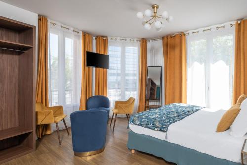 a bedroom with a bed and chairs and windows at The Originals Boutique, Hôtel Le Marignan,Le Havre Centre Gare in Le Havre