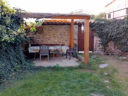 eine Terrasse mit einem Tisch und Stühlen unter einem Sonnenschirm in der Unterkunft casa Berastegui, experiencia rural en el cidacos in Enciso