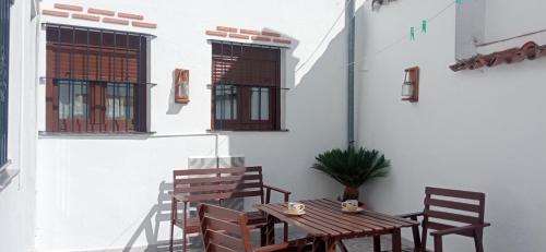 a patio with a wooden table and chairs at Casa Monte Los Peñasquitos in Cazalla de la Sierra