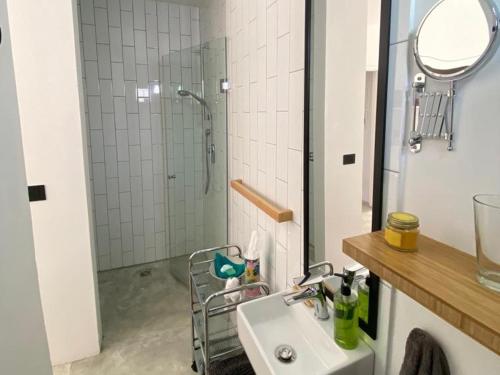 a bathroom with a sink and a shower with a mirror at Yellow Door Hermanus in Hermanus