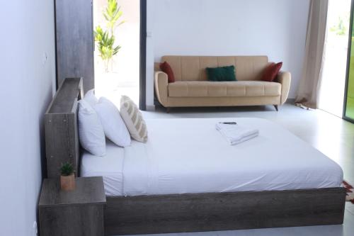 a bedroom with a large bed and a couch at Residence Clean Apparts in Abidjan