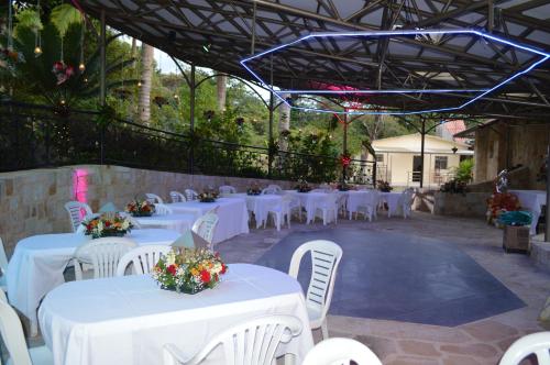 a group of white tables and chairs with flowers on them at Finca Andalucia con Piscina en Mesitas in El Colegio