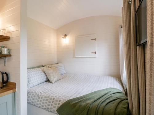 a small bedroom with a bed in a small room at Beech in Kemble