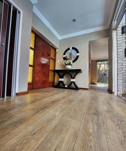 an empty living room with a table and a mirror at FM GUEST LODGE Comfort, Tranquility & Peace of Mind in Johannesburg