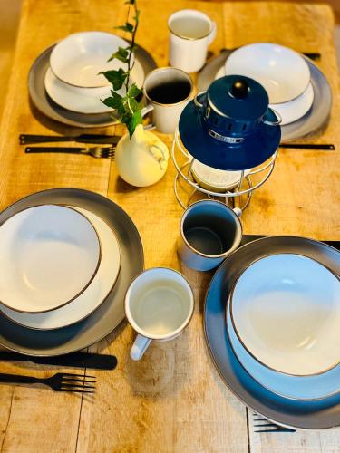 a wooden table with plates and utensils on it at Kåseberga Hideout in Kåseberga