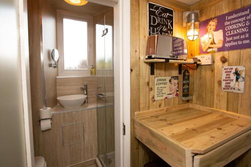 a bathroom with a wooden tub with a sink at The Baby Grand- Quirky & Compact in Torquay