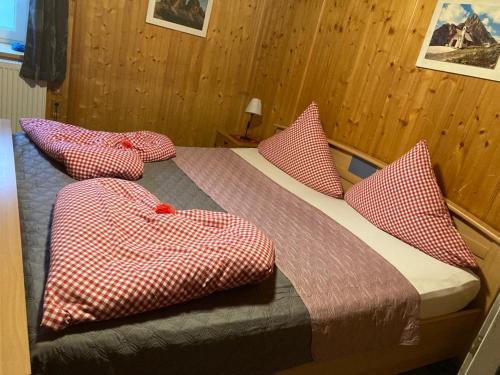 a bedroom with a bed with red and white pillows at Ferienhaus Gertrud in Nesselwängle