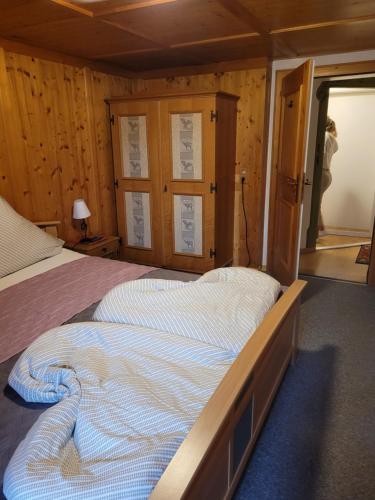 a large bed in a room with wooden walls at Ferienhaus Gertrud in Nesselwängle