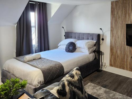 a bedroom with a large bed and a tv at Quantock Loft Studio 3 in Rochester