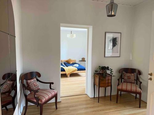 a living room with two chairs and a bedroom at KvarteretSkatan! in Ystad