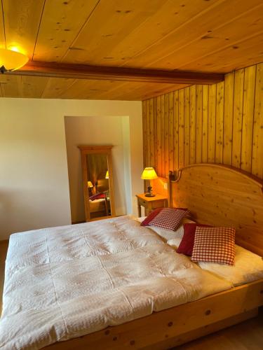 a large bed in a room with wooden walls at Weissmies Lodge in Saas-Grund