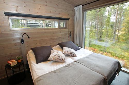 een slaapkamer met een bed en een groot raam bij Villa Kanger Ruka1 in Kuusamo