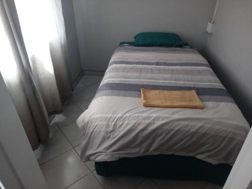 un letto con un asciugamano in una stanza di Las Palmas Day & Night Guest House a Pretoria