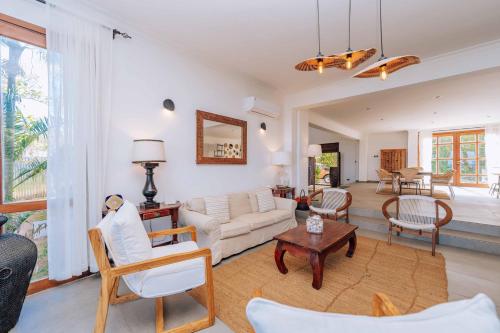 un soggiorno con un divano e un tavolo di Karabai Villa a Matemwe