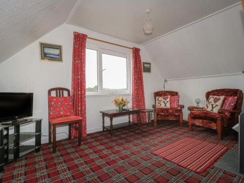 a living room with two chairs and a television at Dunard Villa in Stornoway