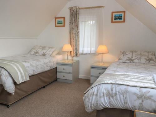 a bedroom with two beds and two lamps on tables at Dunard Villa in Stornoway