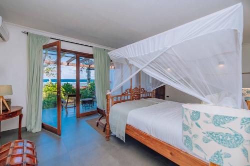 una camera da letto con un letto e vista sull'oceano di Karabai Villa a Matemwe
