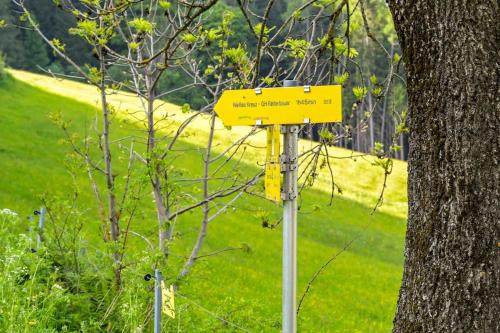 a yellow sign on a pole next to a tree at Ferienwohnung Schaffer in Obdach