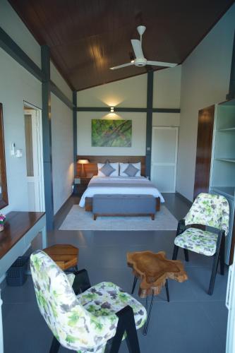 a bedroom with a bed and two chairs at Cinnamon Serenity Villa in Badulla