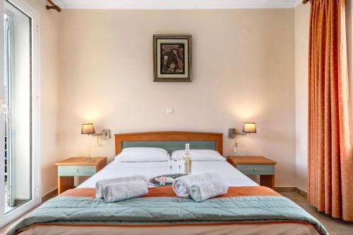 a bedroom with a bed with two towels on it at Spyros apartment in Markópoulon