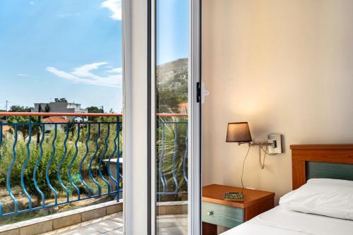a bedroom with a view of a balcony at Spyros apartment in Markópoulon