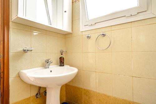 a bathroom with a sink and a window at Spyros apartment in Markópoulon