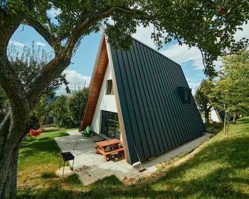 a small house with a black roof and a picnic table at Aruna Bran in Bran