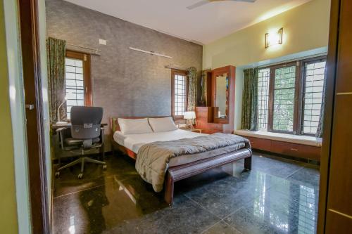 a bedroom with a bed and a desk and windows at HomeSlice Manor in Bangalore