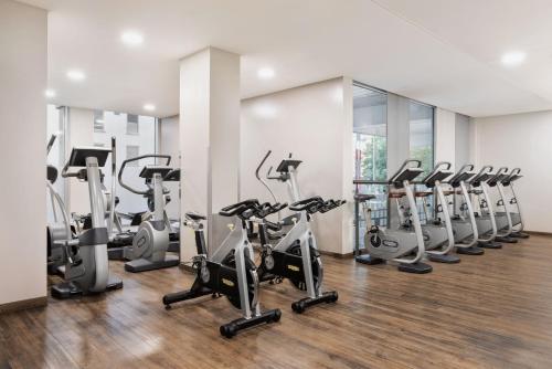 林茲的住宿－林茨萬怡酒店，一间健身房,里面设有一排跑步机和椭圆机