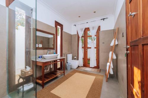 a bathroom with a sink and a mirror at Karabai Villa in Matemwe