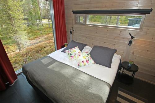 um quarto com uma cama com almofadas e uma janela em Villa Kanger Ruka 2 em Kuusamo