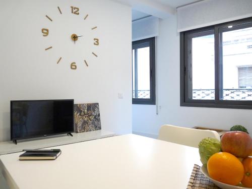 ロスピタレート・デ・リョブレガートにあるMarbarcelona Apartments Mas 11 bのテーブル(フルーツボウル付)と時計が備わるお部屋