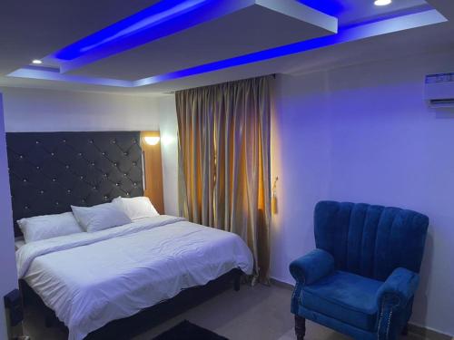 1 dormitorio con 1 cama y luz azul en DND Apartments, en Benin City