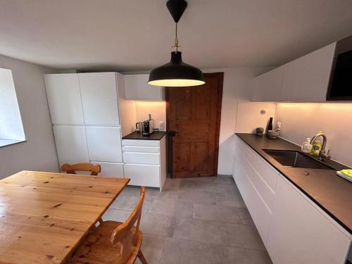 uma cozinha com uma mesa de madeira e uma sala de jantar em Casa Biala Dimora - Ski IN/OUT em Vigens