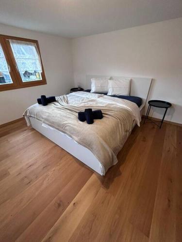 a bedroom with a large bed and a wooden floor at Casa Biala Dimora - Ski IN/OUT in Vigens