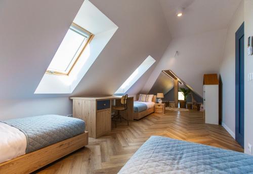 a attic bedroom with two beds and a desk at Lisie Sprawki in Bebło