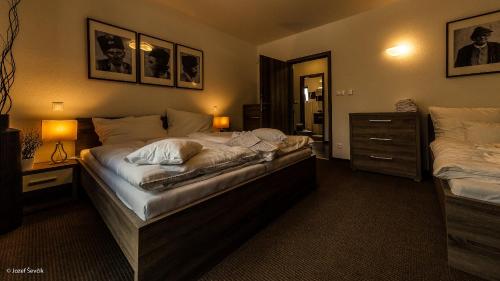 een slaapkamer met 2 bedden, een dressoir en 2 lampen bij Mucha Apartments in Terchová