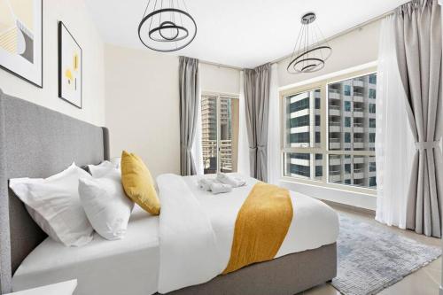 - une chambre blanche avec un grand lit et une fenêtre dans l'établissement StoneTree - Furnished 1BR with Modern Design, à Dubaï