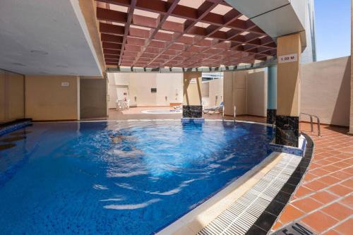 - une grande piscine d'eau bleue dans un bâtiment dans l'établissement StoneTree - Furnished 1BR with Modern Design, à Dubaï
