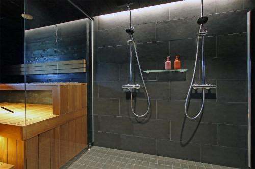 a bathroom with a shower with two hose at Villa Kanger Ruka 2 in Kuusamo