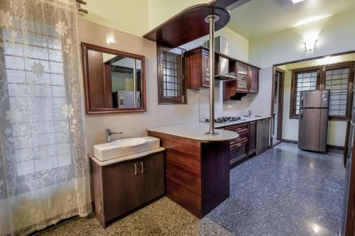 a large kitchen with a sink and a refrigerator at HomeSlice Manor in Bangalore