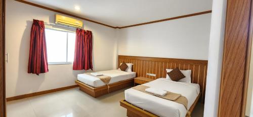 a small room with two beds and a window at Eden Park in Patong Beach