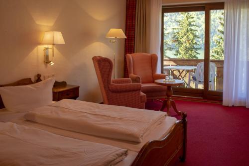 um quarto de hotel com uma cama e uma varanda em Seehotel Weissensee em Füssen
