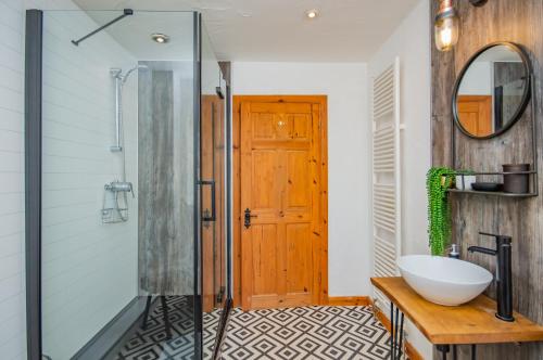 a bathroom with a shower and a sink and a mirror at Cosy Farm Conversion In The Heart Of Pembrokeshire in Pembrokeshire