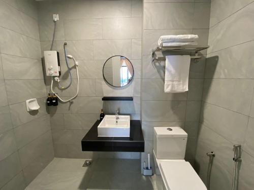 a bathroom with a sink and a mirror and a toilet at Sky Trees Your Perfect Gateway with Pool & Facilities in Johor Bahru