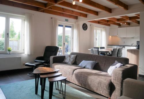 a living room with a couch and a kitchen at Nova Park V88 in De Haan